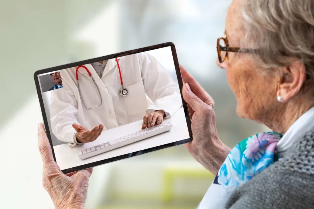 Senior woman attending a virtual telehealth consultation on a tablet