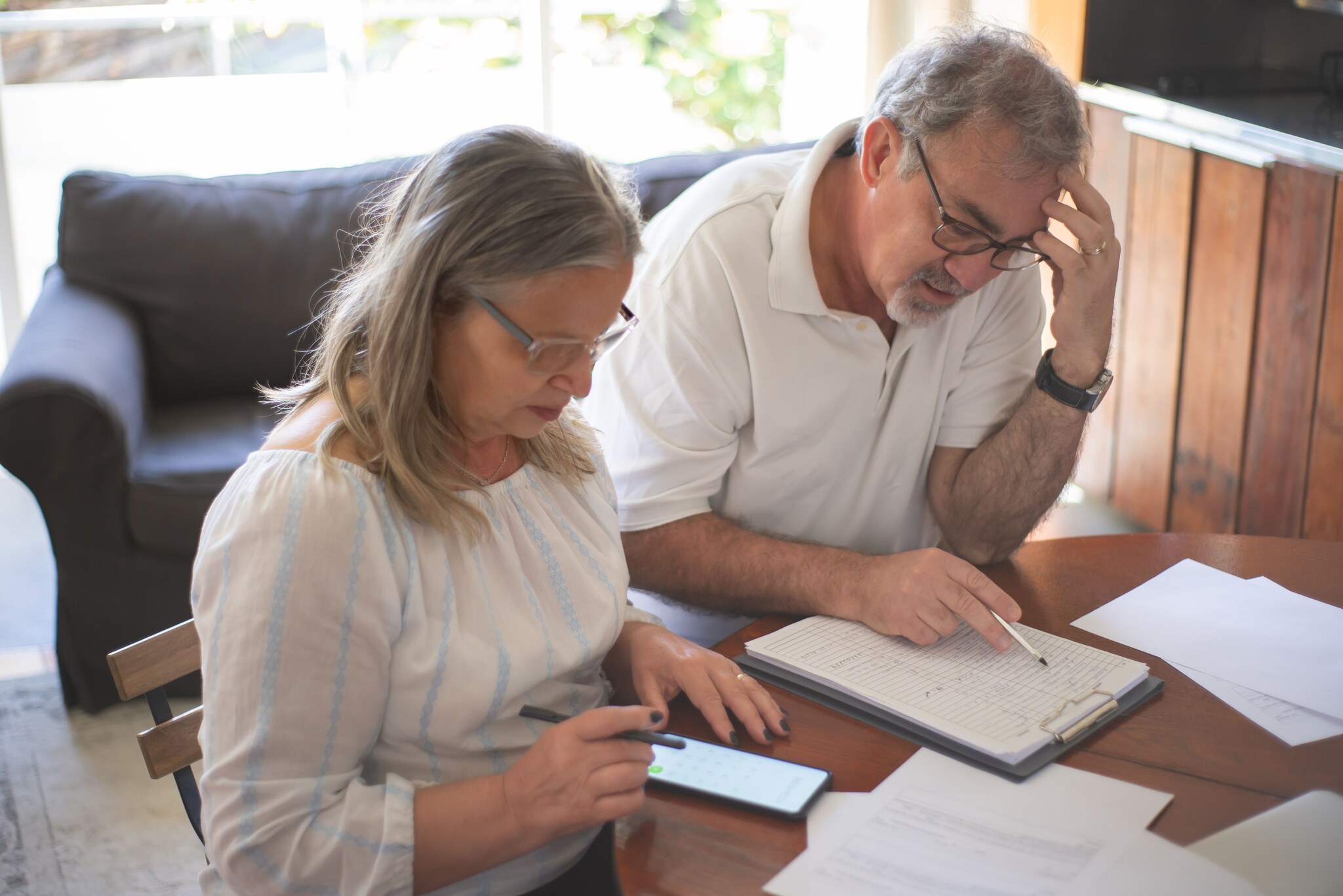 Older couple reviewing Medicare plan documents and prescription costs together